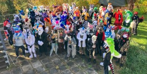 around 50 fursuiters standing in a tight group outside