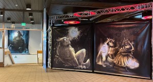 a big room with stairs down and three large pieces of animal artwork on the walls